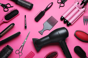 Flat lay composition of different professional hairdresser tools on pink background