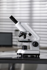 Modern medical microscope on metal table in laboratory