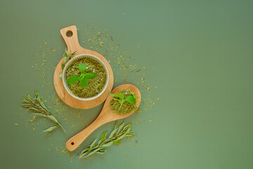 Dried stevia and green twig in a round cup and a wooden spoon.Sugar substitute.Stevia...