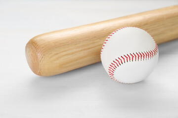 Baseball bat and ball on white wooden table. Sports equipment