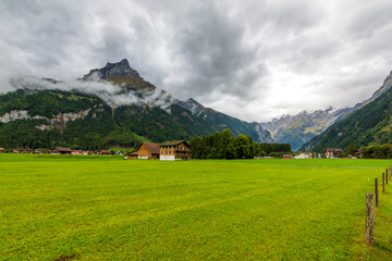 A rural village in the Swiss Alps just outside the town of Engelberg, Switzerland, on an overcast, rainy day.