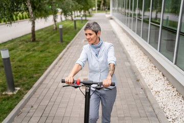 Obraz premium One woman mature senior adult female with eco electric kick scooter