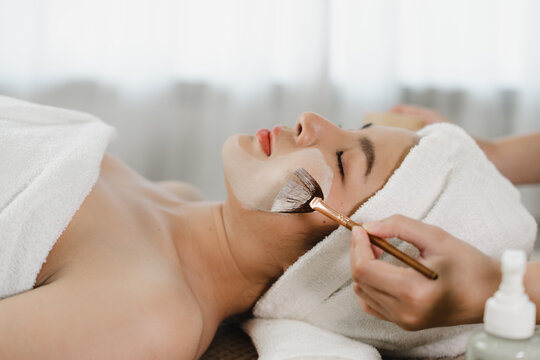 Pretty Asian Woman Getting A Facial Treatment Therapy To Renew Close-up Skin Care At Spa Center.