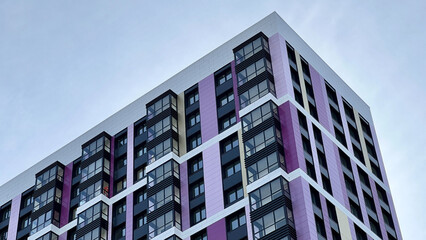 The facade of the building in purple,geometric patterns from windows and balconies, the colored...