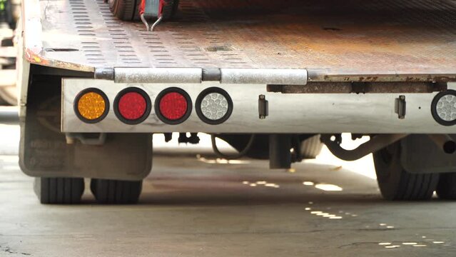 Car tire secured with belt for safety on flatbed tow truck,Securing the load of a car transporter,