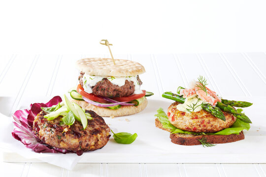 Three healthy hamburger options with different toppings, studio shot on white background