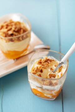 Fruit parfait with nut topping on a blue background