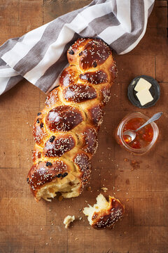 Challah bread with raisins served with butter and jam on butcher block