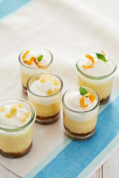 Five mini citrus and ginger cheesecakes in shot glasses