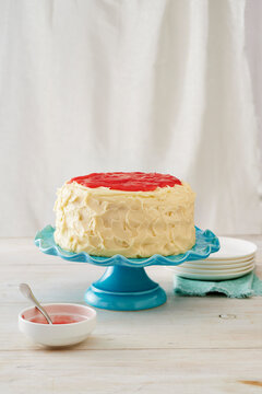 Vanilla rhubarb cake on a turquoise cake stand with white background