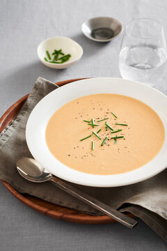 Bowl of seafood bisque soup with chives and pepper