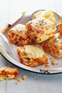 Bacon and cheese biscuits with butter on a rustic white plate