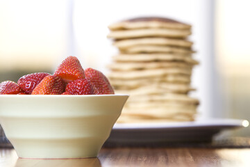 Bowl of Strawberries and Stack of Pancakes