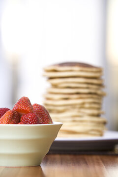 Bowl of Strawberries and Stack of Pancakes