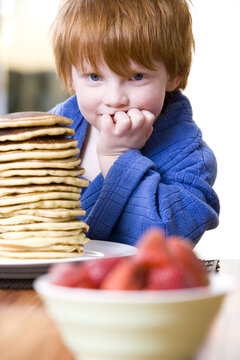 Little Boy Eating a Stack of Pancakes
