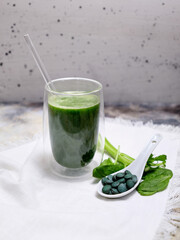 spirulina smoothie with a few leafs on a white background