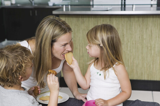 Mother and Children Eating Cookies