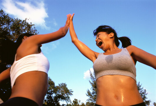 Two Women Giving High Five Perspiring Outdoors