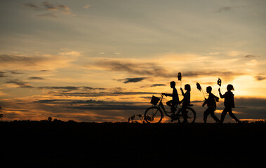Fototapeta na wymiar Children riding bicycles and running In the early light of the day as the sun shines