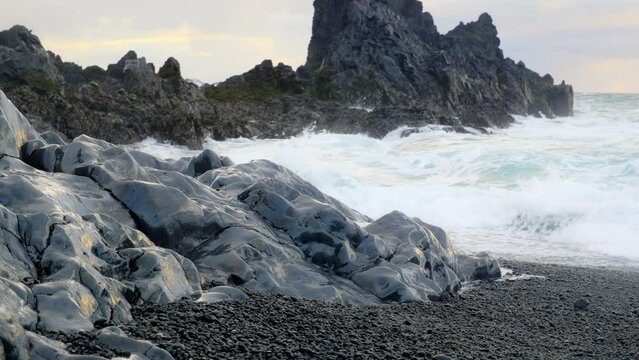 Icelandic Coastline with Black Cliff at Sunset, Volcanic Rocks with Blue North Atlantic Ocean Water, Shot in 8K Resolution 4320p