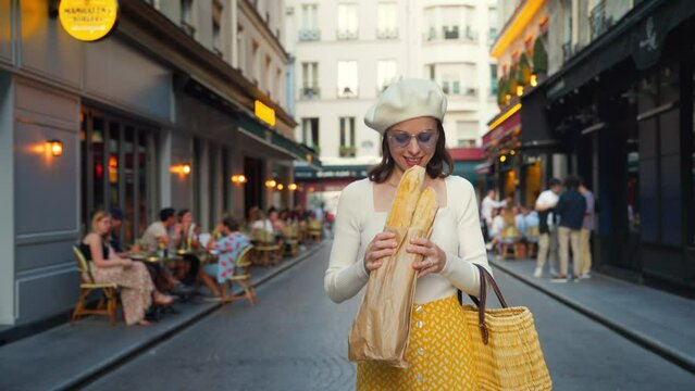 Young woman in a yellow skirt eating french baguette from a bakery