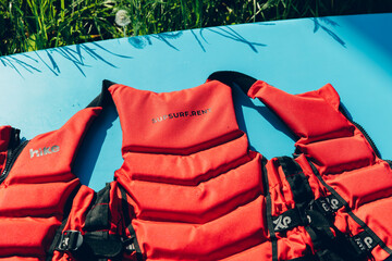 Life jackets of red color lie on a marine-colored sap board. Uniforms and equipment for...