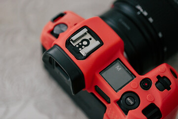 Mirrorless camera in a red silicone case, close-up. Mode m on the scoreboard. View from above