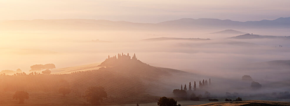 Typical Tuscany landscape in morning with fog, in foreground is Podere Belvedere a farm near San Quirico d'Orcia. Val d'Orcia, Orcia Valley, Siena district, Tuscany, Toscana, Italy.