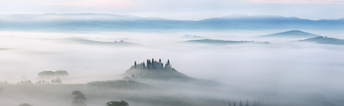Typical Tuscany landscape in morning with fog, in foreground is Podere Belvedere a farm near San Quirico d'Orcia. Val d'Orcia, Orcia Valley, Siena district, Tuscany, Toscana, Italy.