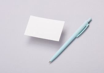 Blank business card and pen on gray background. Mockup for presentations and corporate identity