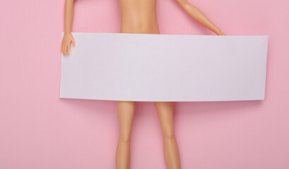 Creative layout. Doll with an empty white banner on a pink background
