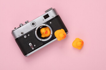 Camera with rubber ducks on a gray background. Creative layout