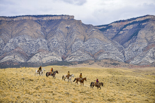 Cowboys and Cowgirls riding horse in wilderness, Rocky Mountain, Wyoming, USA