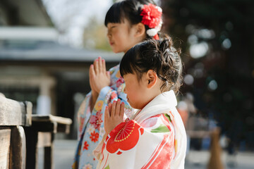お参りする着物姿の幼い姉妹
