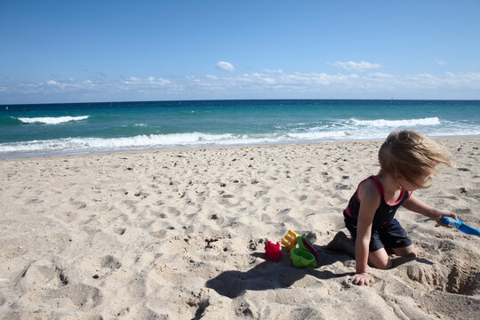 Girl Digging on Beach, Fort Lauderdale, Florida, USA