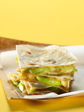 Quesadilla with cheese and apples on parchment paper, studio shot