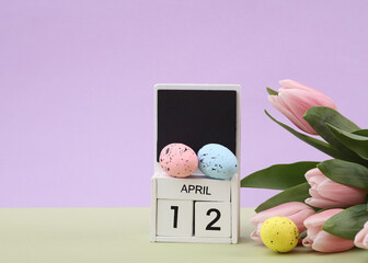 Happy easter. Calendar with date april 12, tulips and easter eggs on pastel background