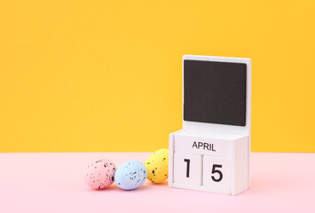 Happy easter. Calendar with date april 15 and easter eggs on yellow background