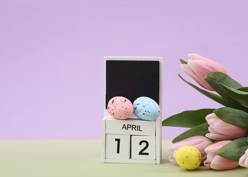 Happy easter. Calendar with date april 12, tulips and easter eggs on pastel background