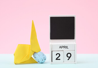 Happy easter. Calendar with date april 29 and easter  rabbit with egg on pastel background