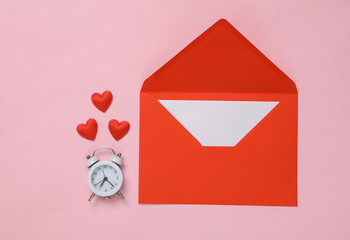 Red envelope and alarm clock with many hearts on a pink background. Valentine's Day