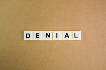 alphabet letters with word Denial and brown background