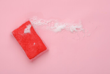 Sponge with foam on a pink background. Cleaning concept