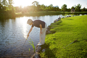 Woman Looking for Golf Ball in Water, Burlington, Ontario, Canada