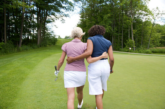 Back View of Women Walking on Golf Course