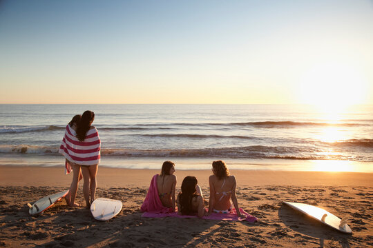 Backview of Young Women with Surfboards on Beach at Sunset, Zuma Beach, California, USA