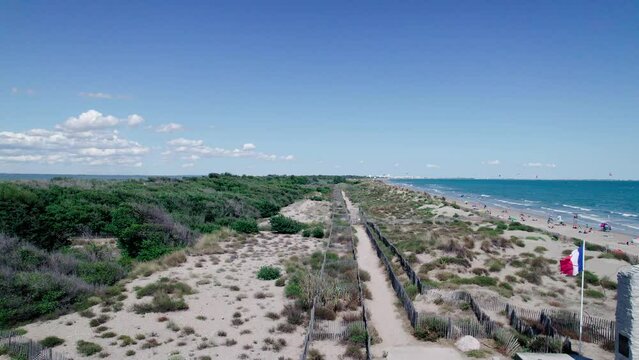 Aerial dolly past people paying their respects at a coastal french monument