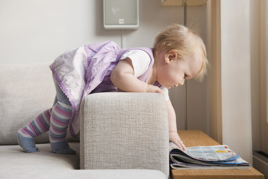 Baby Girl Looking at Newspaper