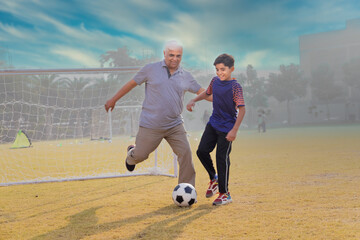 Family playing football outdoors and boy attacking his grandfather.