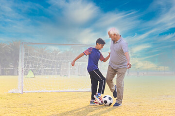 Family playing football outdoors and boy attacking his grandfather.